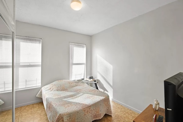 bedroom with light floors and baseboards