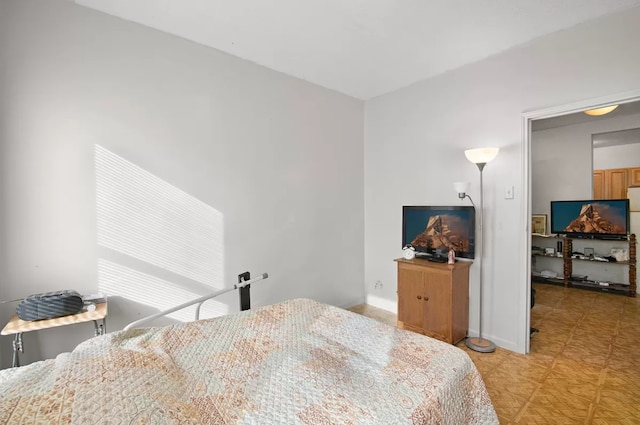 bedroom featuring light floors and baseboards