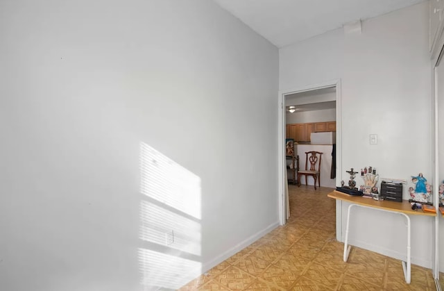 corridor with baseboards and light floors