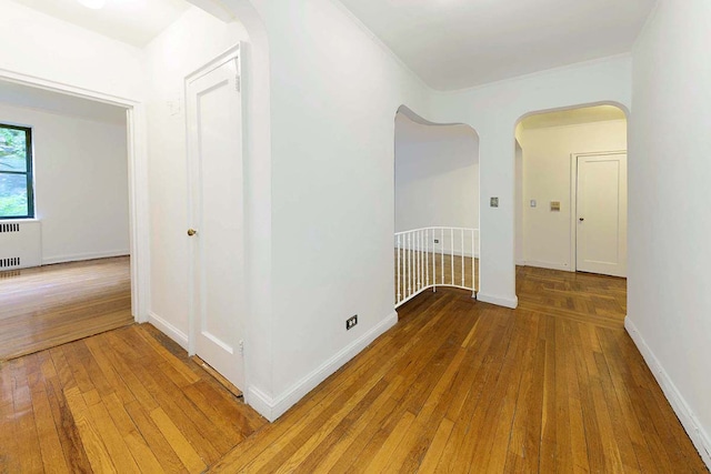 corridor featuring radiator and hardwood / wood-style floors