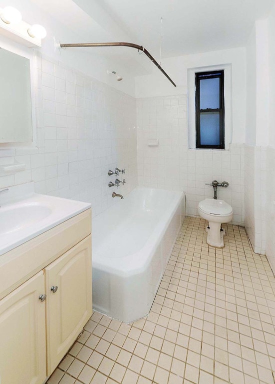 full bathroom featuring shower / bathtub combination, tile walls, vanity, toilet, and tile patterned floors