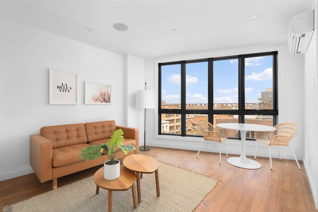 living room featuring wood-type flooring and an AC wall unit