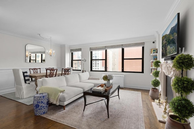 living room featuring an inviting chandelier, crown molding, and wood-type flooring