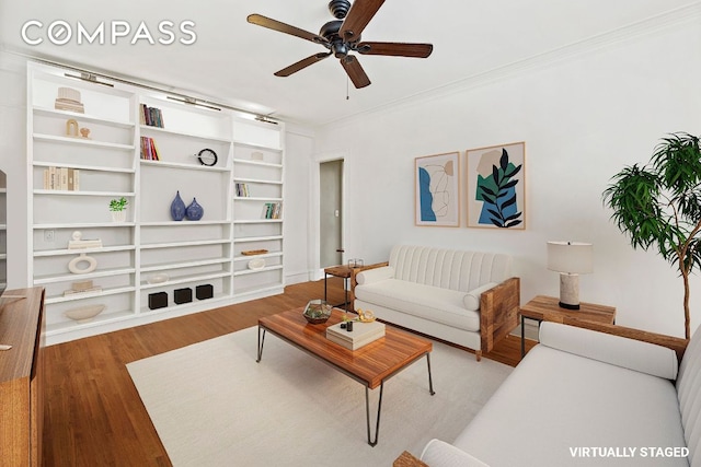 living room featuring wood-type flooring, ornamental molding, and ceiling fan