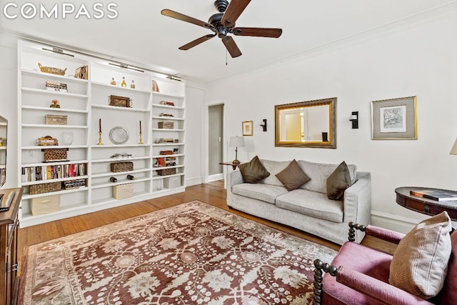 living room featuring ceiling fan, crown molding, and wood-type flooring