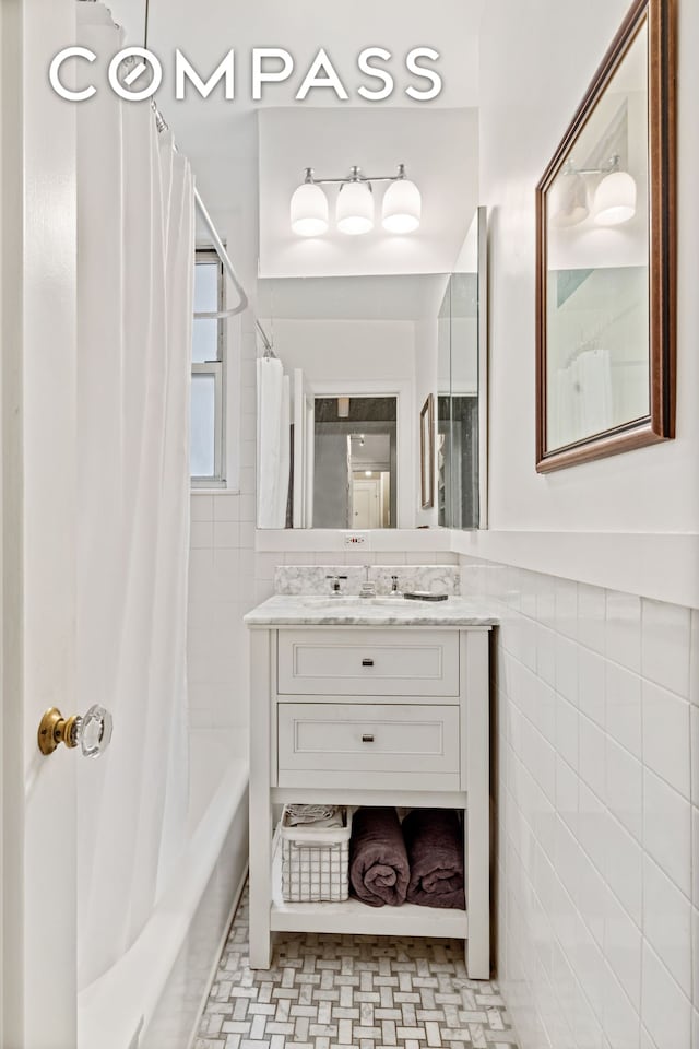 full bathroom with shower / bath combination with curtain, tile walls, and vanity