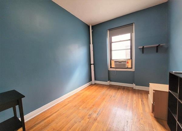 spare room featuring light wood-type flooring, baseboards, and cooling unit