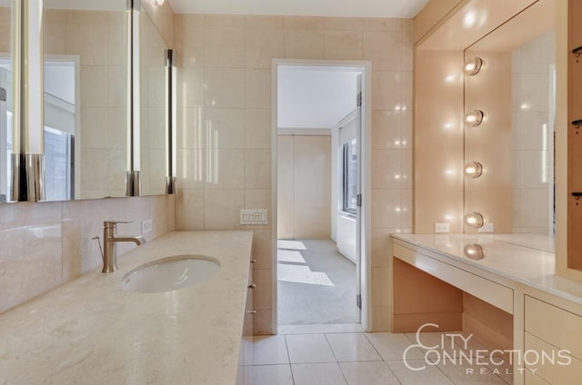 bathroom with backsplash, tile walls, vanity, and tile patterned floors