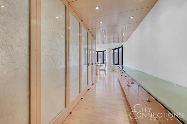 hallway featuring light wood-style floors, recessed lighting, and floor to ceiling windows