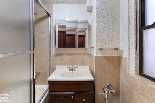 bathroom with vanity and shower / bath combination with glass door