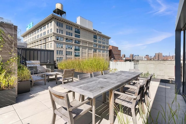 view of patio featuring outdoor dining area, a city view, and area for grilling