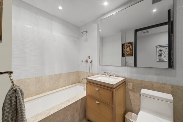 full bathroom with toilet, visible vents, vanity, tiled shower / bath, and tile walls