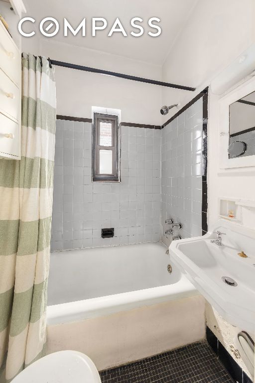 bathroom featuring shower / tub combo, tile patterned floors, and toilet