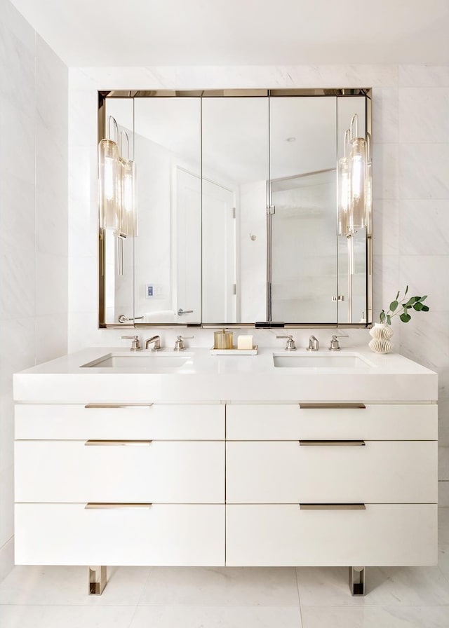 bathroom with double vanity, tile walls, and tile patterned flooring