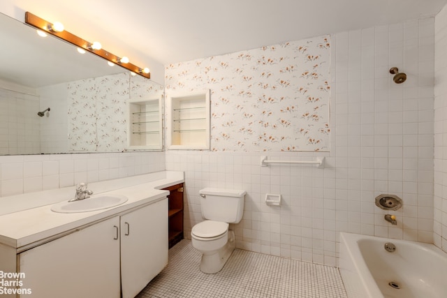 full bathroom featuring tile patterned floors, toilet, tile walls, tiled shower / bath, and vanity