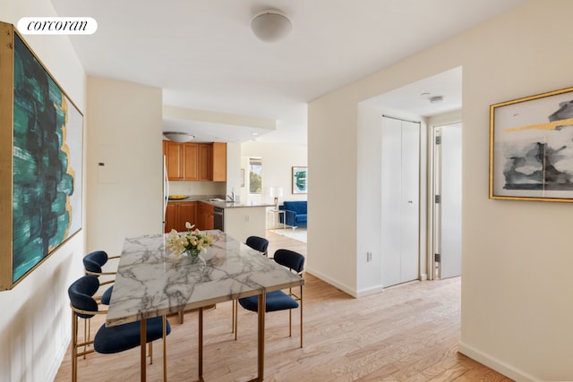 dining area with sink and light hardwood / wood-style floors