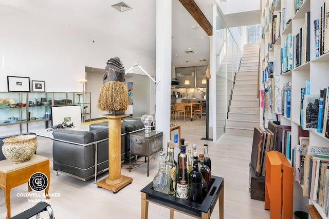 living room featuring stairs, light wood-style flooring, and visible vents