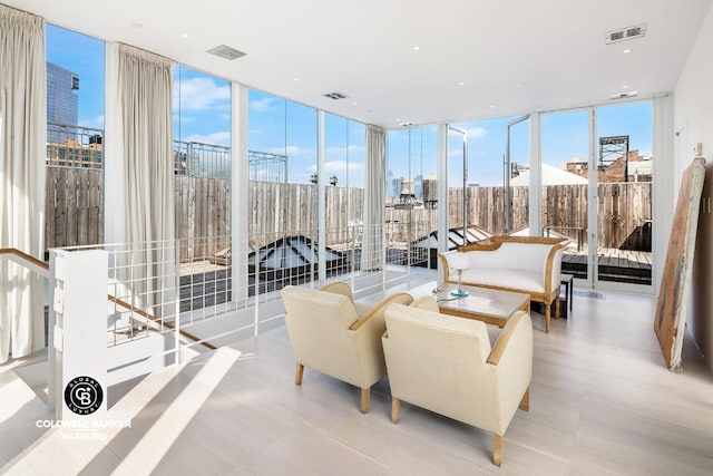 interior space featuring a view of city, visible vents, and floor to ceiling windows