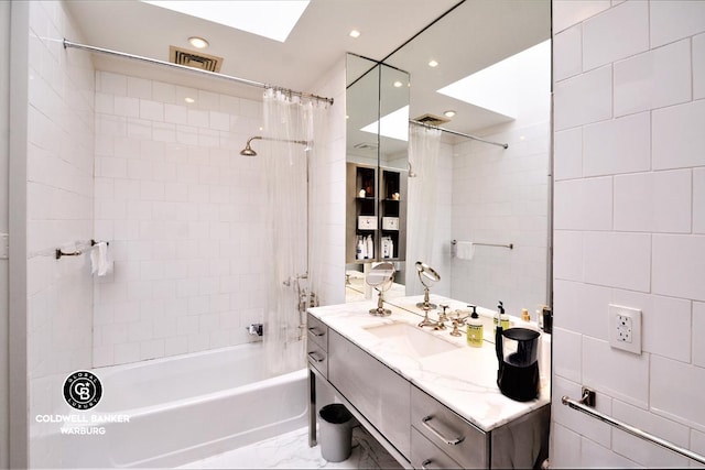 bathroom featuring vanity, tile walls, shower / bath combo, and a skylight