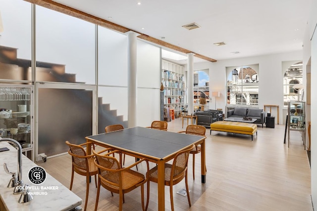 dining area with light wood-type flooring and visible vents