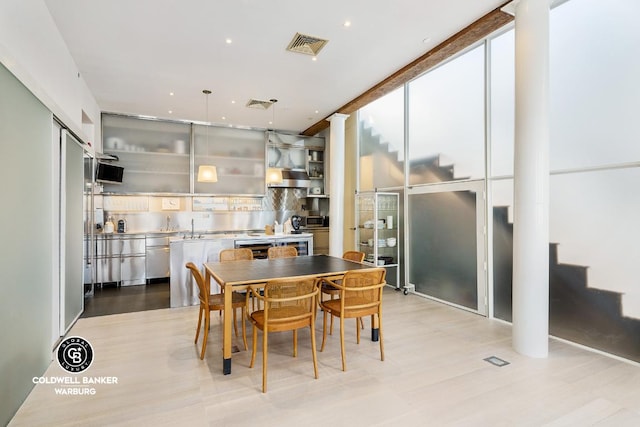 dining room with stairway, decorative columns, floor to ceiling windows, and visible vents