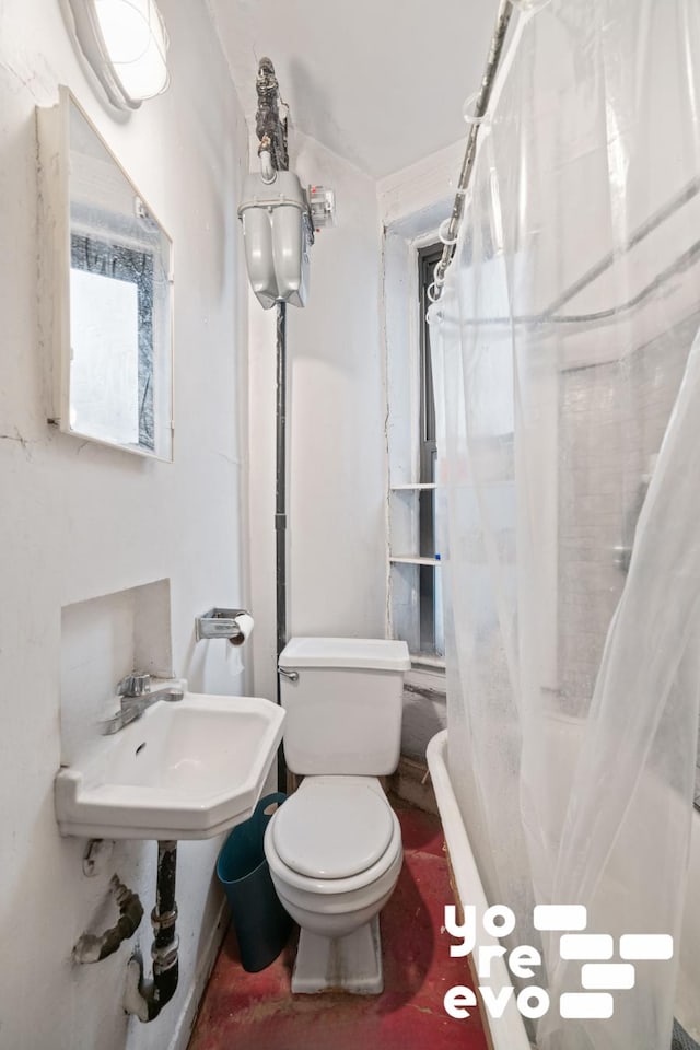 full bathroom featuring curtained shower, toilet, and a sink