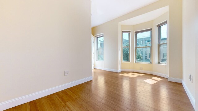 living room featuring ceiling fan with notable chandelier, a wall mounted AC, and light hardwood / wood-style floors