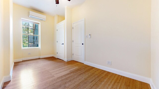 bedroom featuring an AC wall unit, hardwood / wood-style floors, and ceiling fan