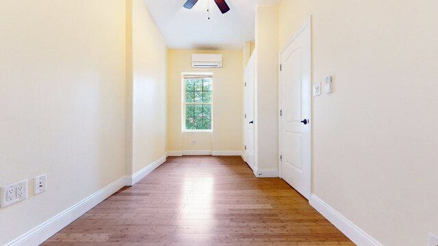 bedroom featuring ceiling fan, wood-type flooring, and a wall unit AC