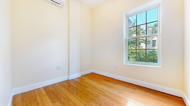 563 W 182nd St, New York City, NY 10033 - unfurnished room featuring light wood-style floors, baseboards, and an AC wall unit