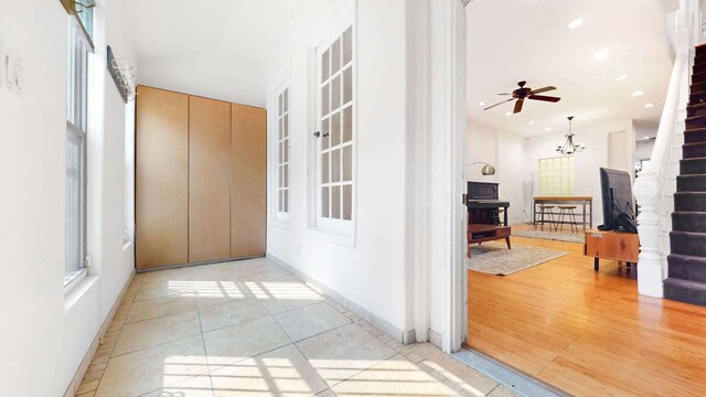 corridor featuring an inviting chandelier and light hardwood / wood-style flooring