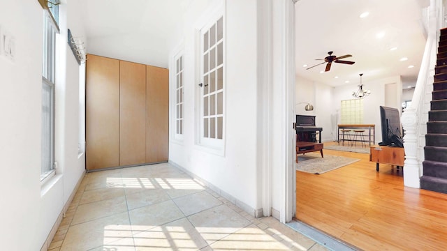 563 W 182nd St, New York City, NY 10033 - corridor featuring stairway, baseboards, light tile patterned floors, recessed lighting, and a chandelier