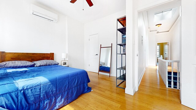 563 W 182nd St, New York City, NY 10033 - bedroom with a wall mounted air conditioner, light wood finished floors, and ceiling fan