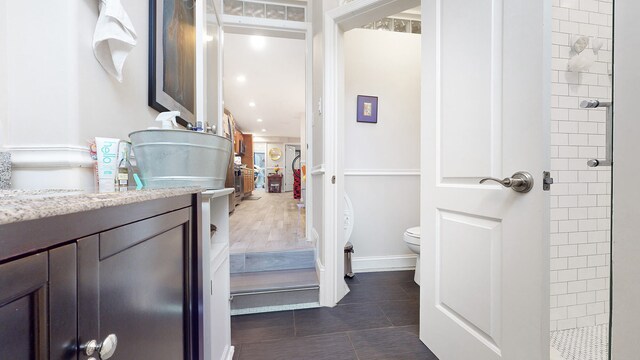 563 W 182nd St, New York City, NY 10033 - full bathroom with toilet, vanity, a tile shower, tile patterned flooring, and baseboards