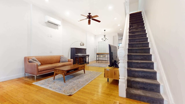 563 W 182nd St, New York City, NY 10033 - living room with stairway, an AC wall unit, baseboards, ceiling fan, and light wood-style floors