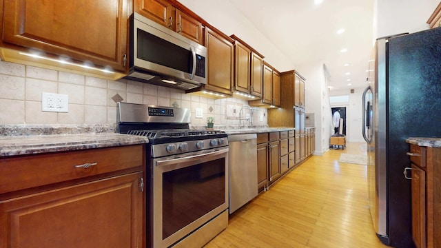 563 W 182nd St, New York City, NY 10033 - kitchen with stainless steel appliances, light wood-style floors, backsplash, a sink, and recessed lighting
