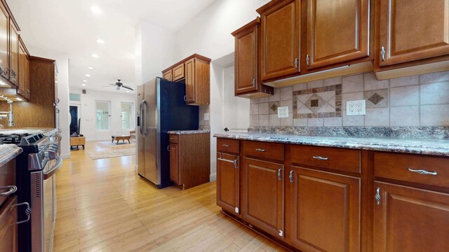 563 W 182nd St, New York City, NY 10033 - kitchen featuring appliances with stainless steel finishes, a ceiling fan, brown cabinets, light wood-style flooring, and decorative backsplash