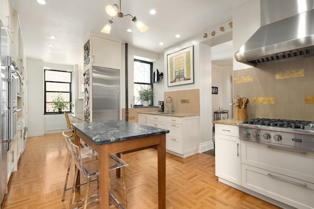 kitchen featuring light parquet floors, white cabinetry, and range hood