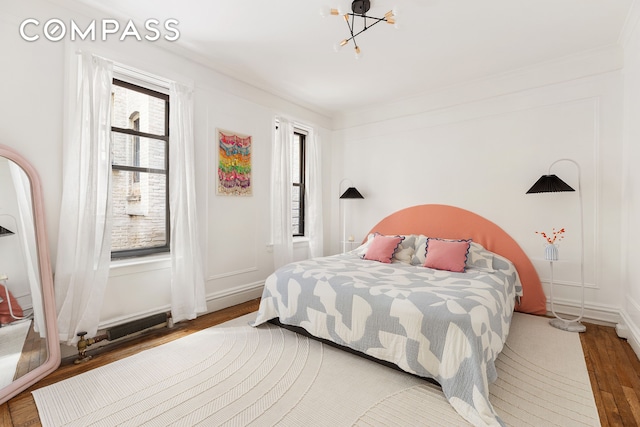 bedroom featuring crown molding, baseboards, and wood finished floors