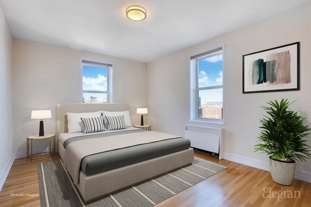 bedroom featuring radiator and light hardwood / wood-style flooring