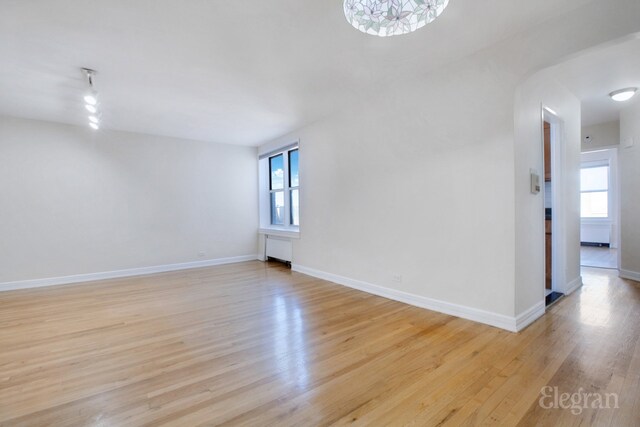 empty room featuring light wood finished floors and baseboards