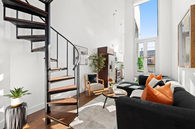 living room featuring hardwood / wood-style flooring and a towering ceiling