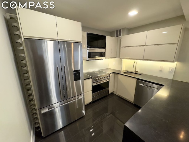 kitchen with appliances with stainless steel finishes, white cabinetry, and sink