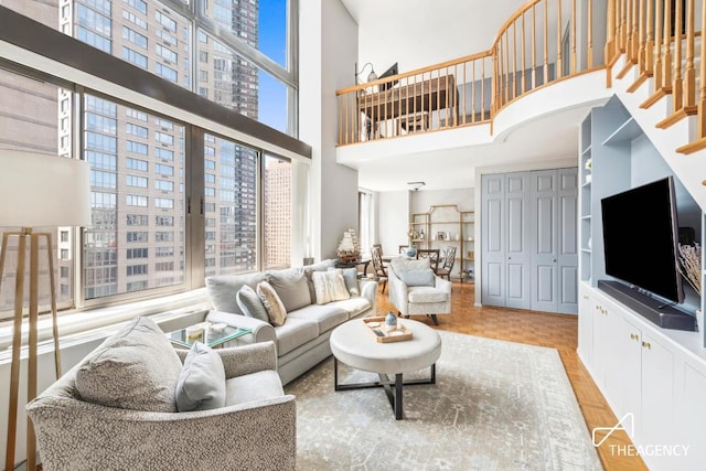 living room featuring light parquet floors and a high ceiling