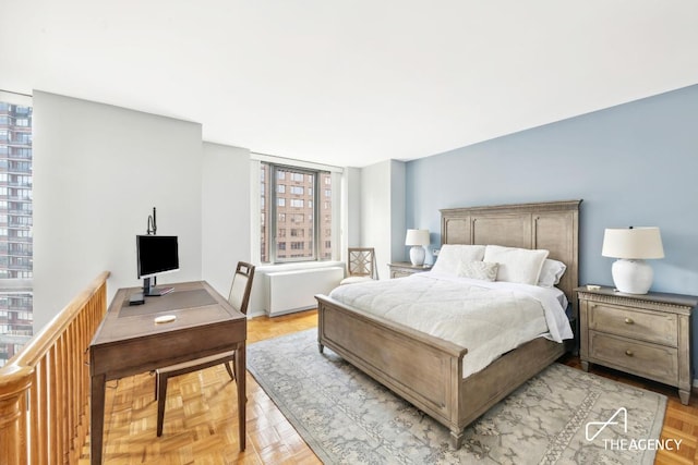 bedroom featuring light parquet floors and radiator heating unit