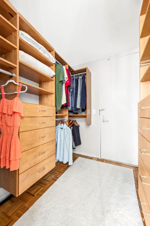 spacious closet with dark parquet floors