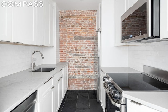 kitchen featuring sink, dark tile patterned flooring, white cabinets, and stainless steel appliances