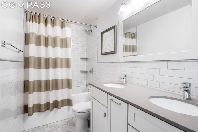 full bathroom featuring toilet, shower / bath combination with curtain, tile walls, and vanity