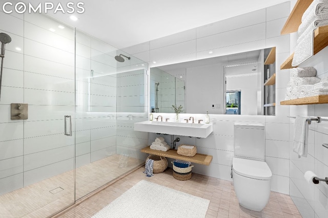 bathroom with tile patterned flooring, sink, tile walls, toilet, and a shower with shower door