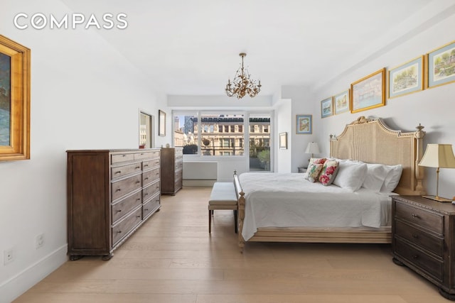 bedroom featuring a notable chandelier and light wood-type flooring